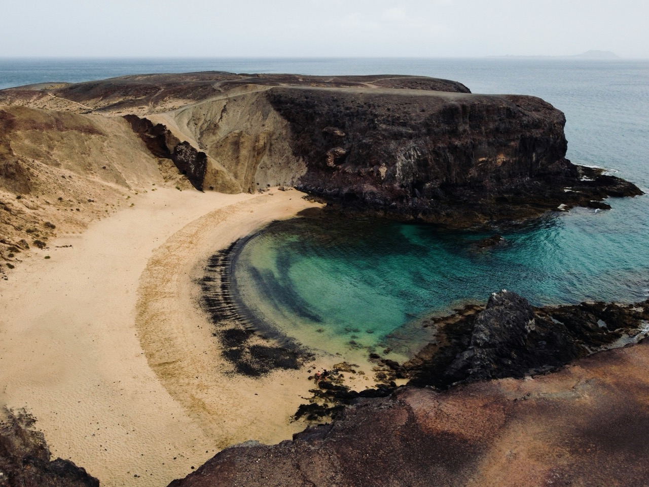 Piesočná zátoka s tyrkysovou vodou na pláži Papagayo na Lanzarote