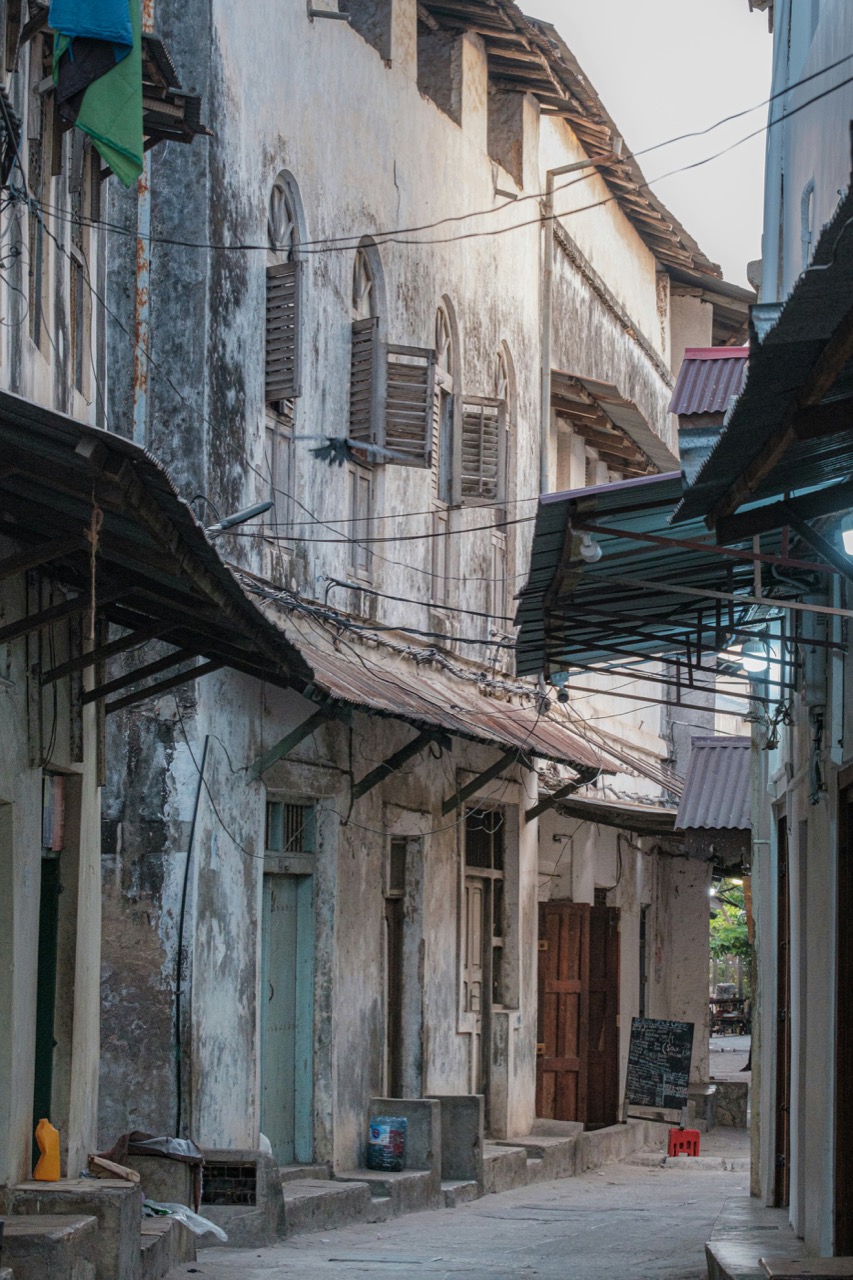 Úzka ulička s vyrezávanými drevenými dverami v Stone Town na Zanzibare