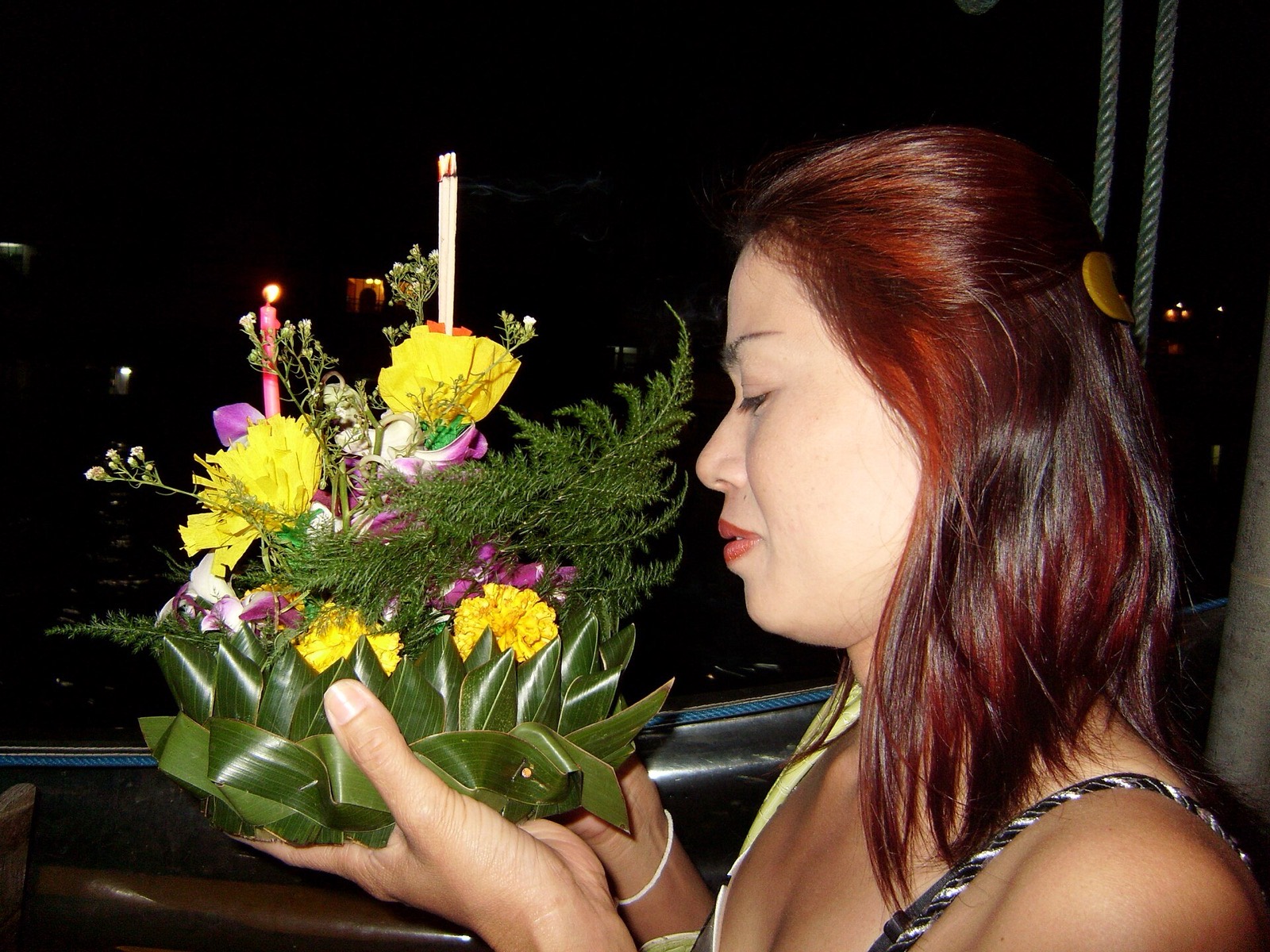 Žena púšťa na vodu krathong počas sviatku Loy Krathong